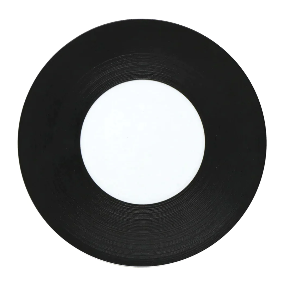 A JL Coquet Hemisphere Dinnerware in Bakelite Black, featuring a sleek black finish and minimalist blank white center, displayed on a white background.