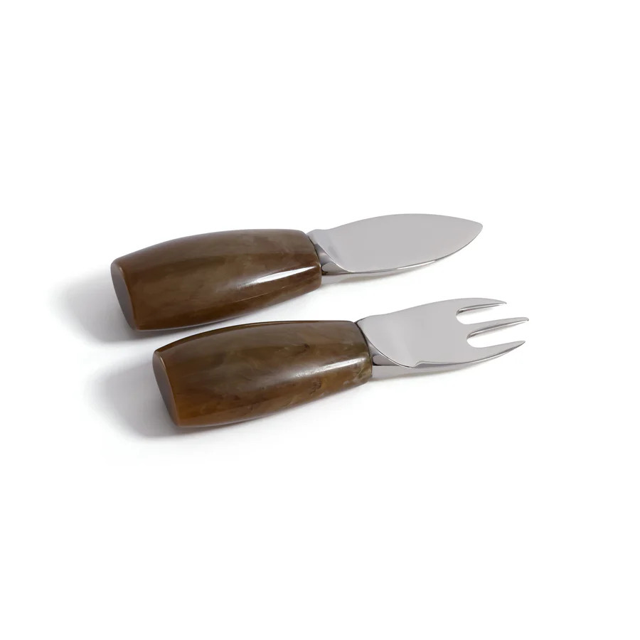The Zodax Borghese Cheese Set includes two cheese knives with wide polished brown handles and stainless steel blades—one with a rounded blade, the other with a two-pronged fork tip—ideal for your next charcuterie board.