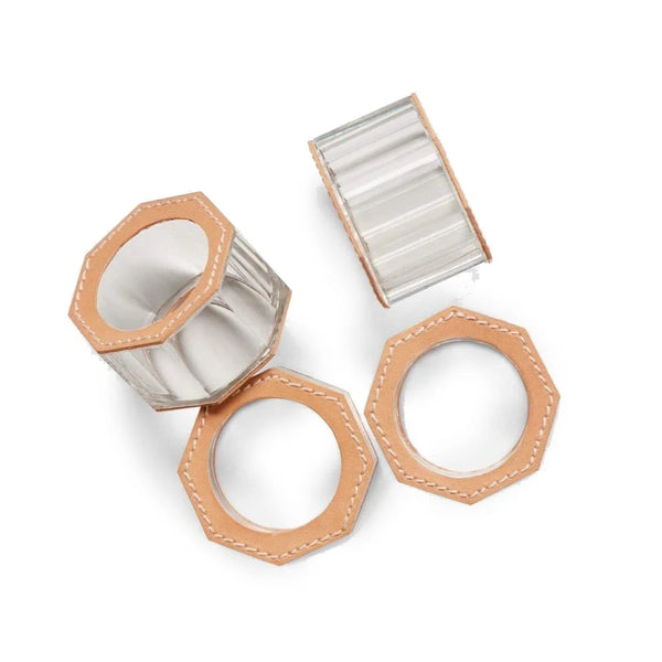 The Arthur Leather Camel Napkin Ring Set of 4 by Blue Pheasant features transparent octagonal crystal rings with tan full-grain leather trim and white stitching; two stand upright and two lie flat on a white background.