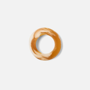 Round, beige-colored object on a light gray background