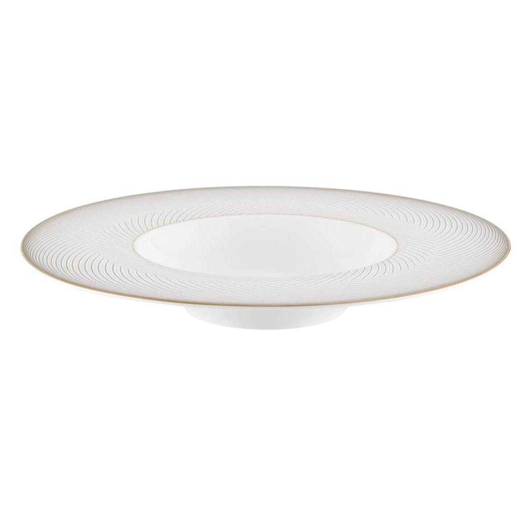 The Oskar Dinnerware by Raynaud is a white Limoges porcelain plate with a wide, shallow bowl, subtle textured rim pattern, and a thin gold border around the edge.