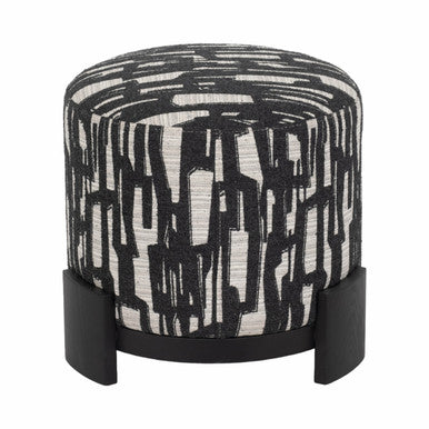The Sagebrook Home Abstract Round Ottoman showcases a black and white graphic fabric and sleek black wooden base, adding modern style to any room. Photographed against a white background.