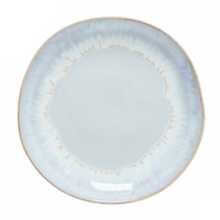 The Brisa Sal Dinnerware by Casafina/Costa Nova is a round, light blue stoneware plate with a subtle gradient pattern, slightly uneven rim, and glossy finish, inspired by the Algarve coast’s natural tones.