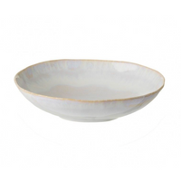 The Brisa Sal Dinnerware by Casafina/Costa Nova is a shallow, round, white stoneware bowl with a subtly uneven rim and beige edge, inspired by the Algarve coast and displayed against a plain white background.