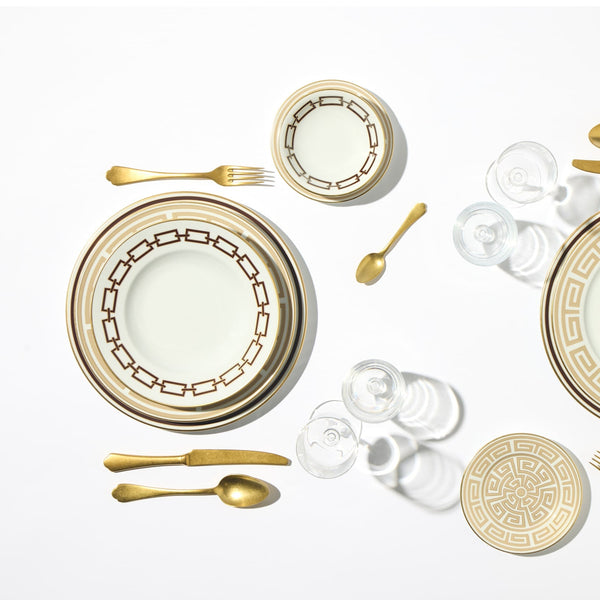 A flat lay of Ginori 1735’s Catene Ebony Brown Dinnerware with gold accents and a porcelain bowl, styled with gold cutlery on a white background.