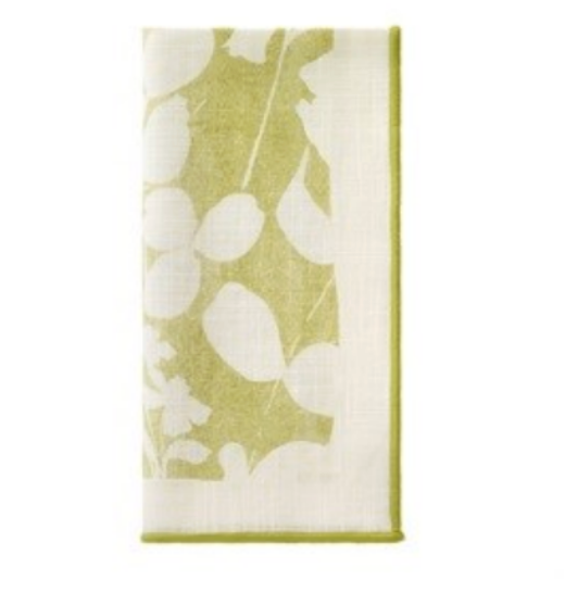 The Bodrum Fleur de Lin Napkin s/4 - Green features a folded white cotton design with a green botanical leaf pattern and matching border, ideal for pairing with floral table linens or a coordinating table runner.