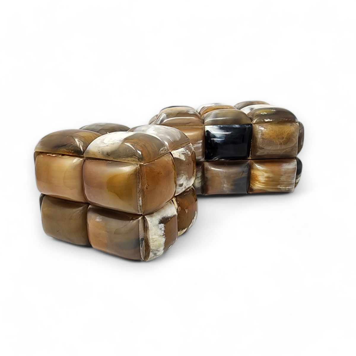 The Bubble Horn Box by A Sanoma Inc features two rectangular, cushion-like forms crafted from glossy, interlocking brown and beige horn tiles—with one black tile—making it a whimsical decor piece shown on a plain white background.