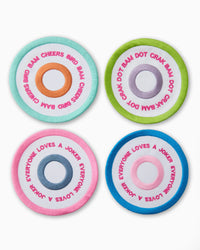 The Bullseye Mah Jong Cocktail Napkin Set by Oh My Mahjong includes four round pastel coasters with concentric circles and fun mahjong phrases like CHEERS BAM and EVERYONE LOVES A JOKER—ideal to pair with your favorite linen napkins.