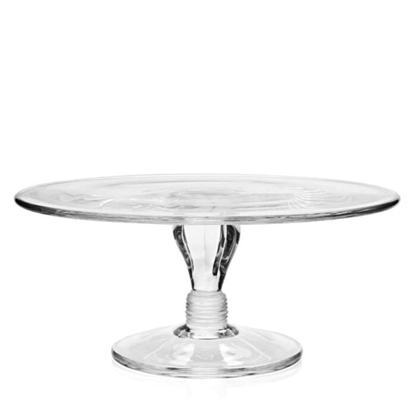 The William Yeoward Classic Cake Stand features a wide, flat top and sturdy round base, ideal for displaying cakes or desserts. Its simple and elegant design is reminiscent of a vintage comport, beautifully showcasing the transparent glass material.