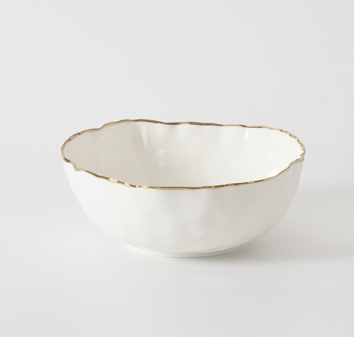 The PAMPA BAY Portofino Serving Bowl features a wavy rim and elegant gold trim, crafted from white porcelain—an ideal addition to your oven-to-table collection.