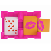 The Canasta Spinner by Canasta Sets is a unique pink card holder featuring three cards—one eight of hearts, two with lipstick kiss prints—perfect for adding flair to your canasta game night on an orange background.