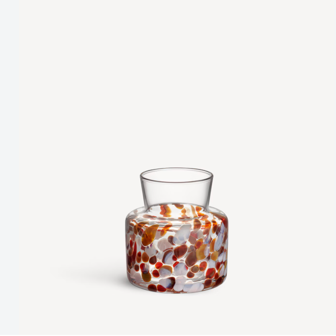 Clear glass Meadow Vase Fall by Kosta Boda with a wide base featuring a colorful pattern of brown, red, and white rounded spots.
