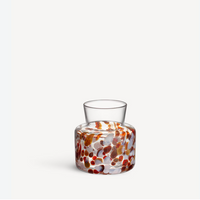 Clear glass Meadow Vase Fall by Kosta Boda with a wide base featuring a colorful pattern of brown, red, and white rounded spots.