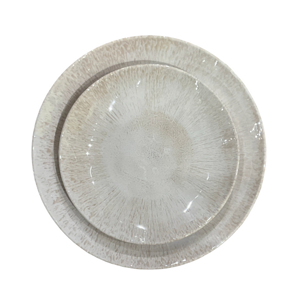 Two round beige Merritt Reactive Glaze Melamine dinnerware plates with a speckled pattern are stacked together, viewed from above on a white background, highlighting their refined stoneware-inspired style.