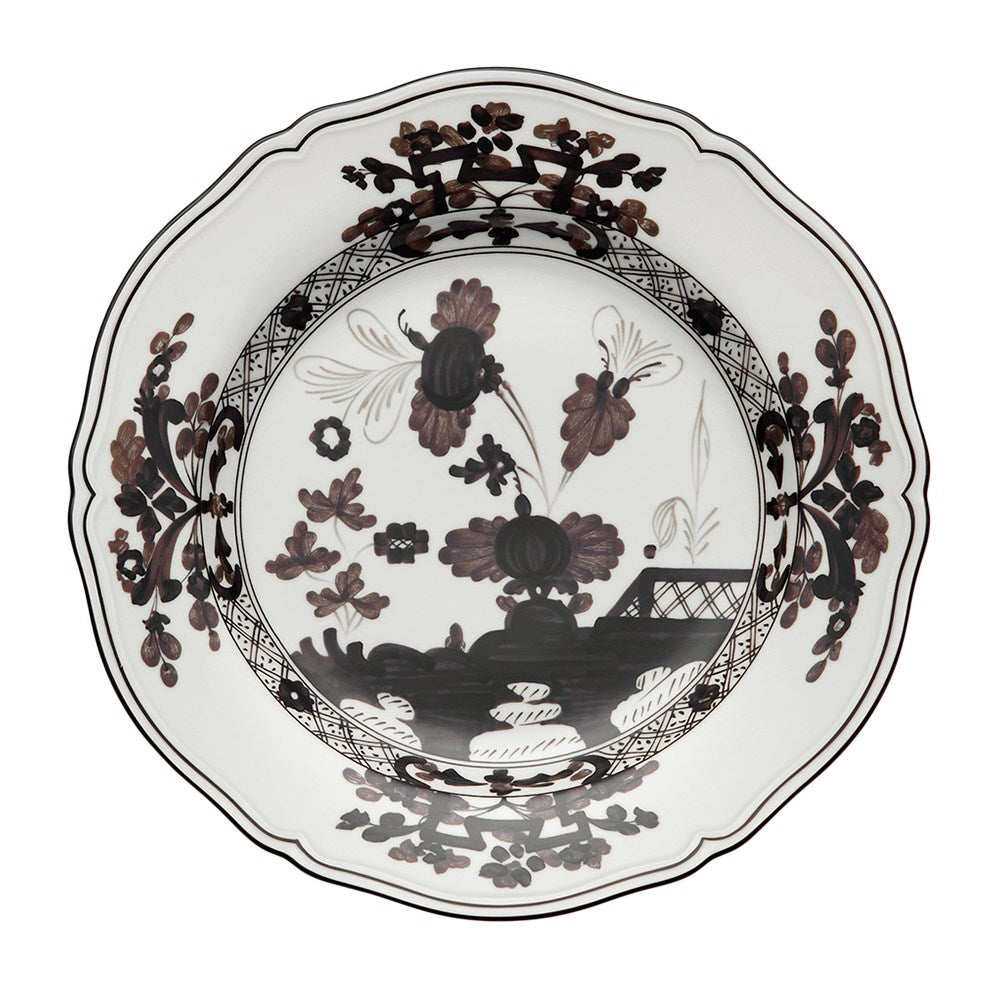 The Oriente Italiano Albus Dessert plate by Ginori 1735 features white porcelain with scalloped edges, adorned with detailed brown and black floral and foliage motifs on the rim and center.
