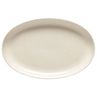A Costa Nova Pacifica Vanilla Dinnerware empty oval ceramic plate, with a smooth surface and subtle speckles, is photographed from above against a white background.