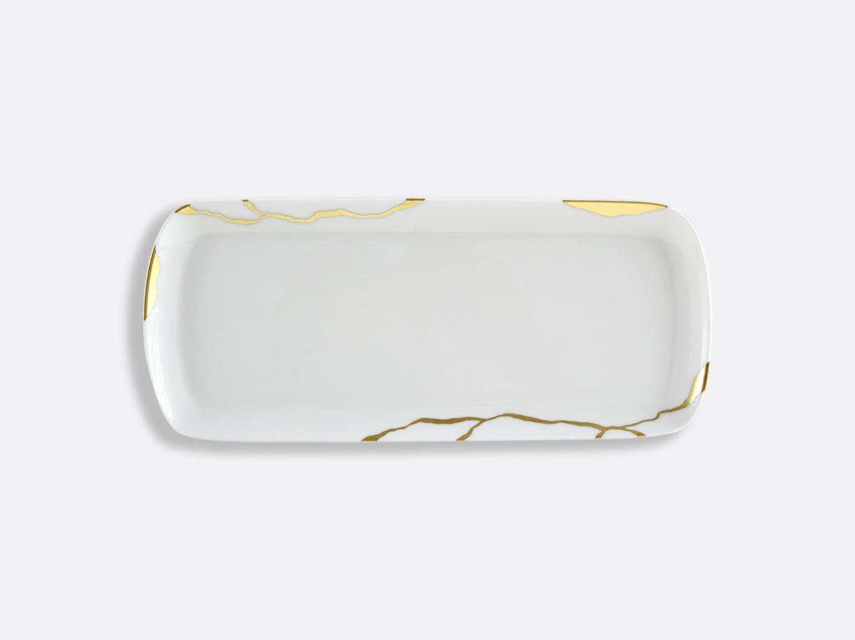 The Bernardaud Kintsugi Dinnerware is a rectangular white ceramic plate with a glossy finish, accented by gold lines and patches inspired by the Japanese art of repairing pottery with gold. Ideal for elegant dinnerware collections.