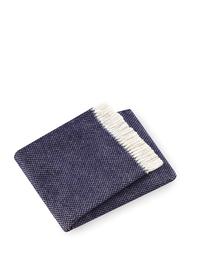 The Grain of Rice Throw by A Soft Idea, shown here in navy blue with a white fringed edge and soft texture, is displayed folded on a white background.