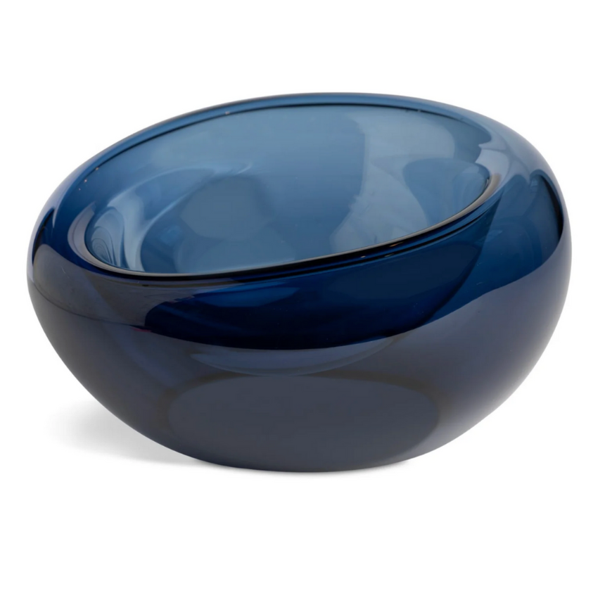 The Axiom Glass Caldera Vessel Medium 9" is a deep blue, round artisan glass bowl with smooth, curved edges and a glossy finish, shown on a white background.