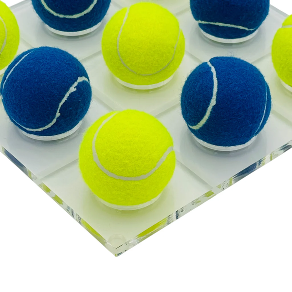 The Luxe Dominoes Tennis Ball Tic Tac Toe - Blue / Yellow features a clear board with blue and yellow tennis balls, ideal as a fun coffee table game or unique tennis gift.