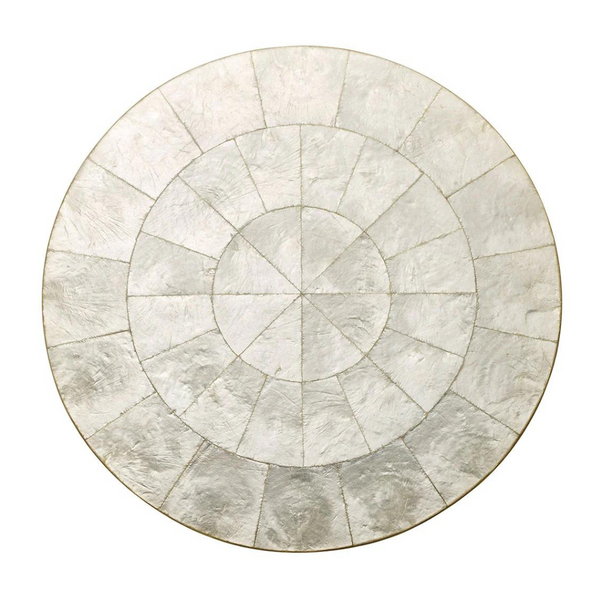 The Kim Seybert Capiz Shell Placemat Set of 4 features a round, geometric pattern with textured, metallic silver segments arranged in concentric circles, echoing the look of hand-crafted Capiz shell.