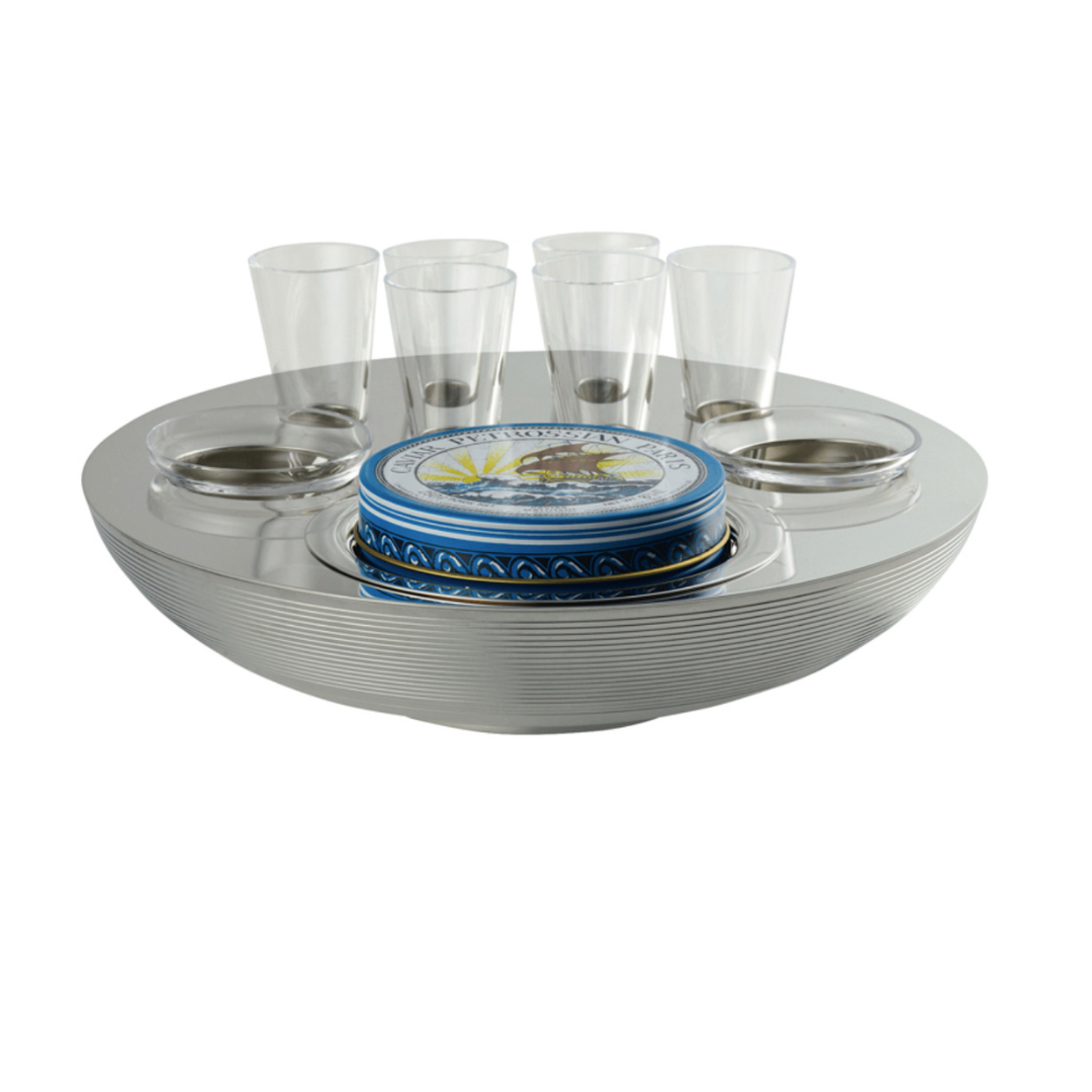 The Ercuis Transat Caviar & Vodka Set includes a round silver tray with grooves, six silver-plated vodka glasses, and a central blue tin—an elegant presentation by Ercuis for serving caviar and vodka.