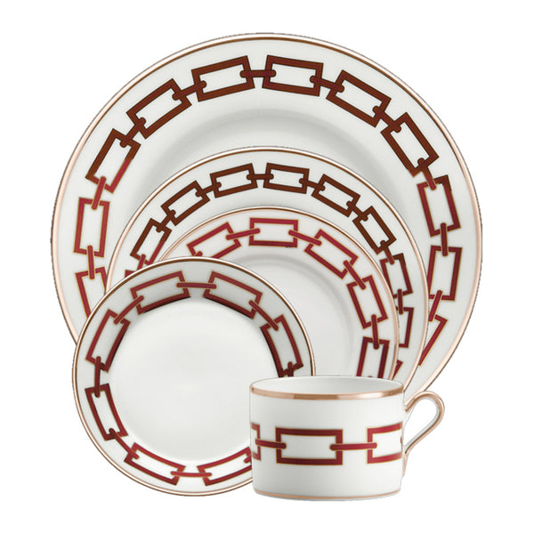 A set of four white porcelain plates and a teacup from the Ginori 1735 Catene Scarlatto Dinnerware collection, each featuring Gio Ponti's bold red chain-link design and elegant gold-trimmed edges.