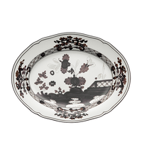 The Oriente Italiano Dinnerware Albus by Ginori 1735 is a handcrafted Italian white porcelain plate with scalloped edges, featuring intricate black and dark brown floral and geometric patterns on the rim and center.