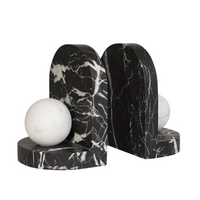 The Blitz Marble Bookend Set by Greg Natale features two black and white marble bookends with white veining and white marble spheres—an elegant new addition to luxury decor. Shown on a plain white background.