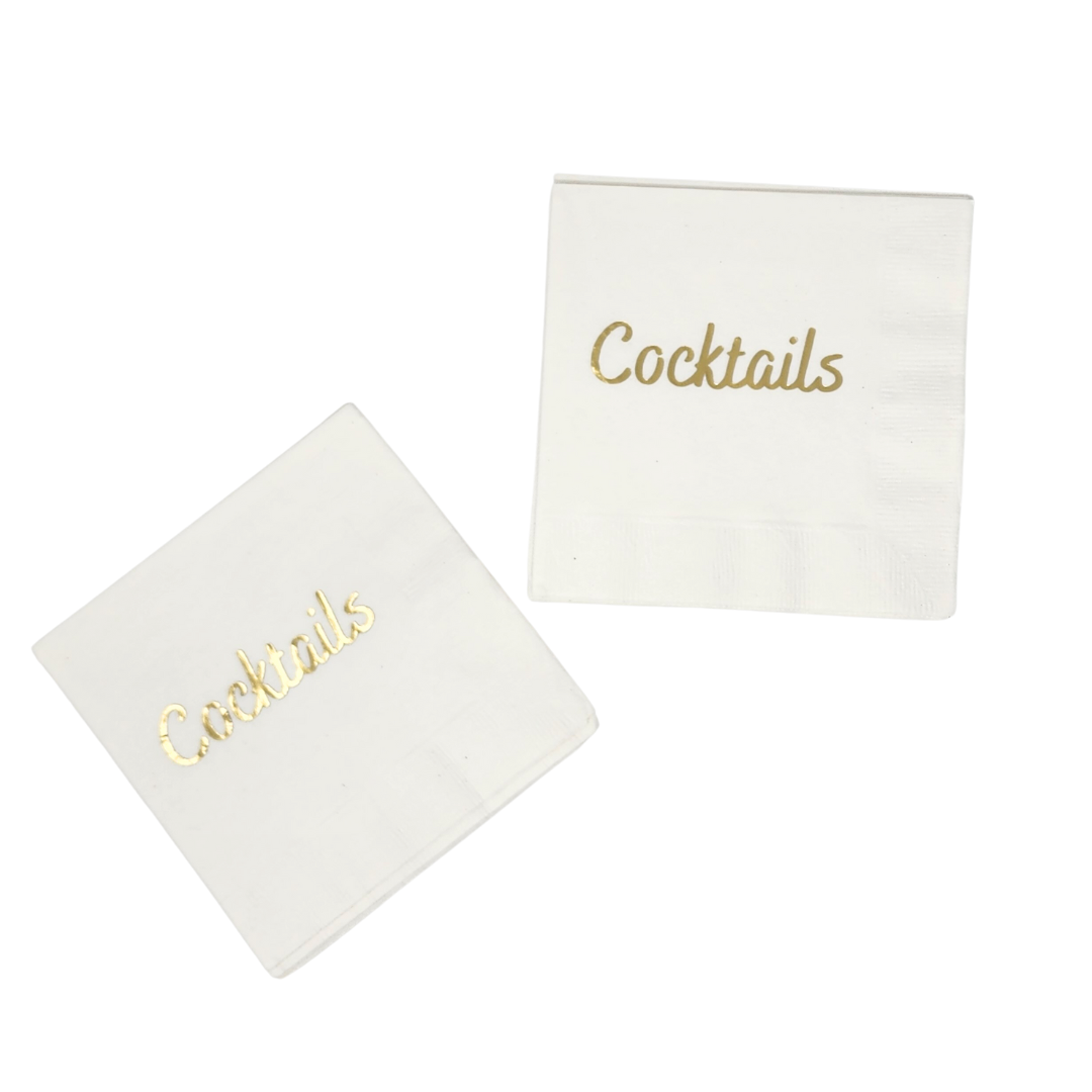 The Cocktails Napkin Pack - White & Gold by Print Appeal features chic white napkins with "Cocktails" in elegant gold foil—one angled, one upright—perfect for your next celebration.