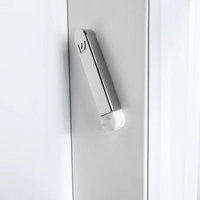A sleek, metallic door handle with a small logo and a rounded, Carrara Marble-like white end is mounted vertically on a white door next to the Anna New York Coluna Mezuzah Marble & Silver - Small.