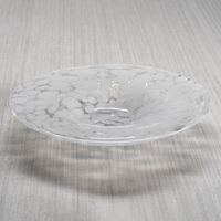 The Zodax Confetti Glass Bowl 14.25" is a food safe, hand-blown glass piece with a marbled white and clear pattern, wide rim, and a slight central depression, displayed on a light-colored textured surface.