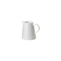 A small, white Raynaud Mineral Dinnerware Glazed White porcelain pitcher with a textured surface, curved handle, and narrow spout is set against a plain white background.
