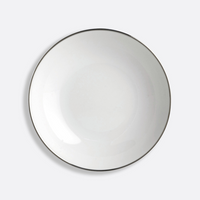 The Cristal Coupe Dinnerware by Bernardaud features a plain white ceramic plate with a thin platinum rim, photographed from above against a light gray background and inspired by Bernardaud’s renowned Limoges craftsmanship.