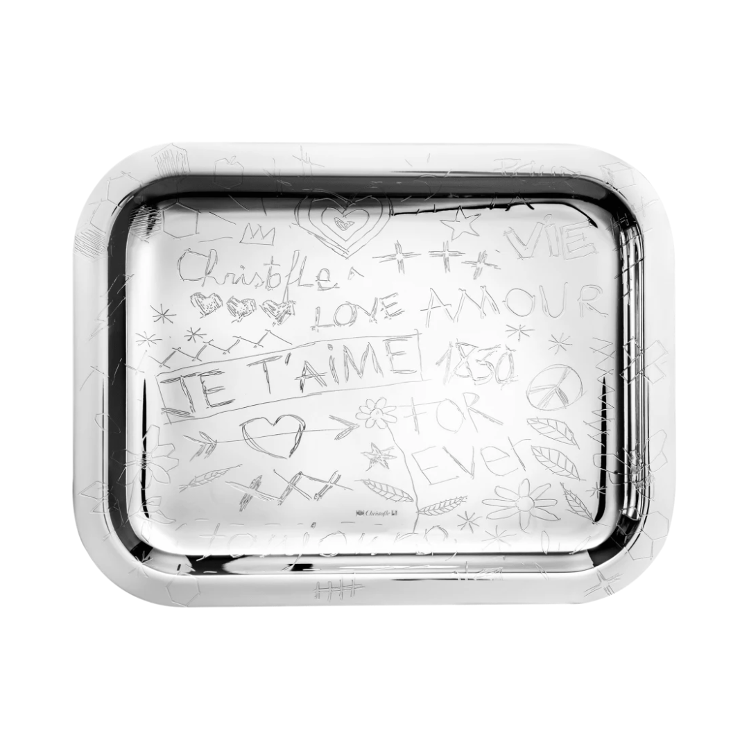 The LOVE Graffiti Christofle Silver Plated Tray by Christofle features hand-drawn doodles, hearts, stars, and French words like LOVE, AMOUR, and JE TAIME etched on its rectangular surface—a playful pop art serving tray.