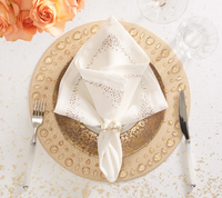Elegant table setting with a gold textured charger, gold-rimmed plate, clear wine glass, white-handled flatware, peach roses, and a Kim Seybert Pin Dot Napkin in white from the White, Natural & Gray Set of 4.