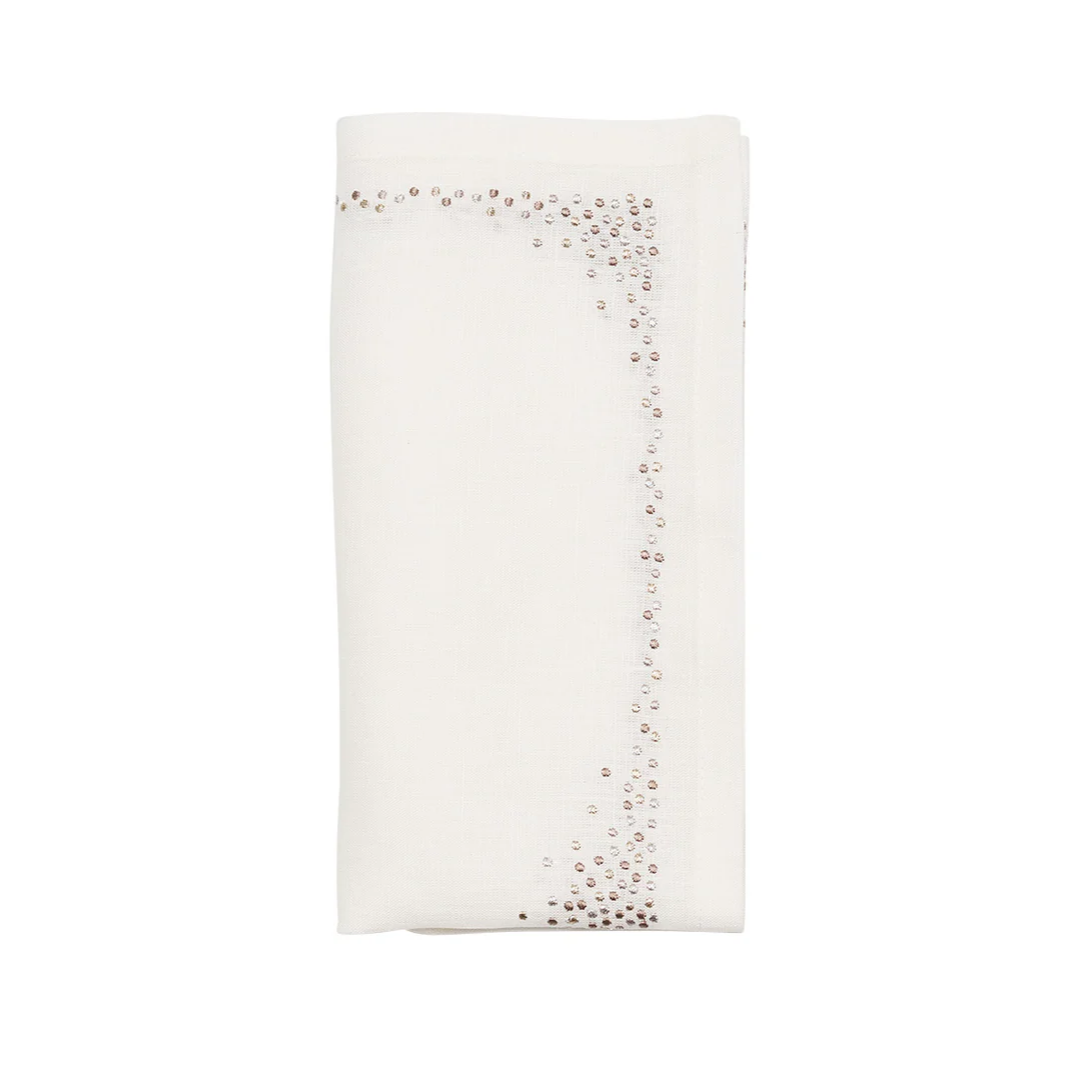 The Kim Seybert Pin Dot Napkin Set of 4 in white, natural, and gray features neatly folded linen napkins with scattered shiny sequin borders for an elegant look.