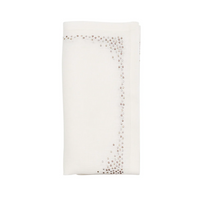 The Kim Seybert Pin Dot Napkin Set of 4 in white, natural, and gray features neatly folded linen napkins with scattered shiny sequin borders for an elegant look.