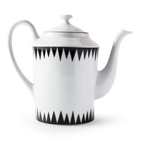 The Punk Dinnerware teapot by Molecot features white Limoges porcelain with a curved spout and handle, accented by black triangular patterns on the top and bottom—a striking piece of modern tableware.