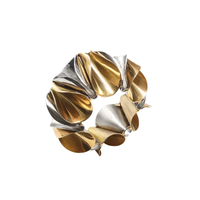 Inspired by Kim Seybert's Enigma Napkin Rings Gold & Silver Set of 4, this sculptural bracelet features alternating gold and silver curved metal pieces in a circular, wave-like pattern, echoing modern luxury table decor.