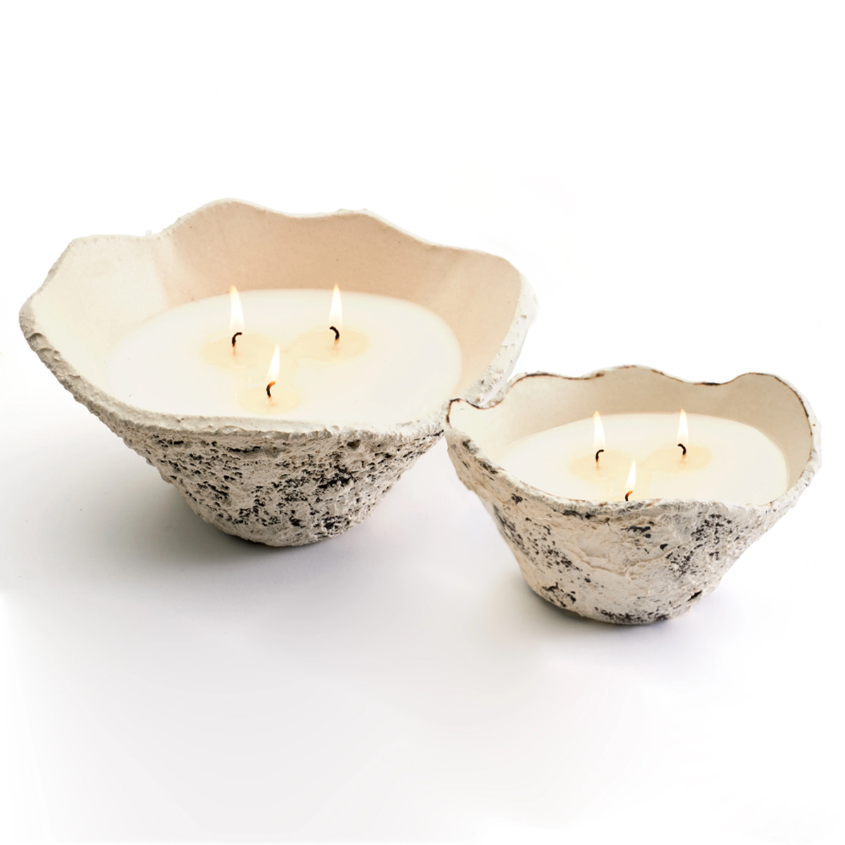 Two Gemma Candle - Sierra Mista - 10" by Dumae feature handmade, rough-textured bowls with a speckled finish and organic shape, each holding a white candle with three lit flames.