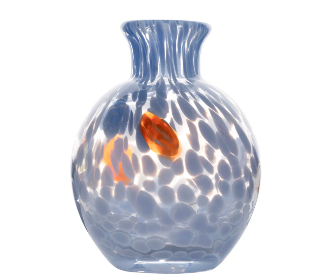 The Cello Spotted Bud Vase - Blue by Abigails is a round, hand-blown vase with a narrow, flared neck, featuring blue and white speckles, translucent spots, and an orange accent that captures the distinctive elegance of Venetian-style design.
