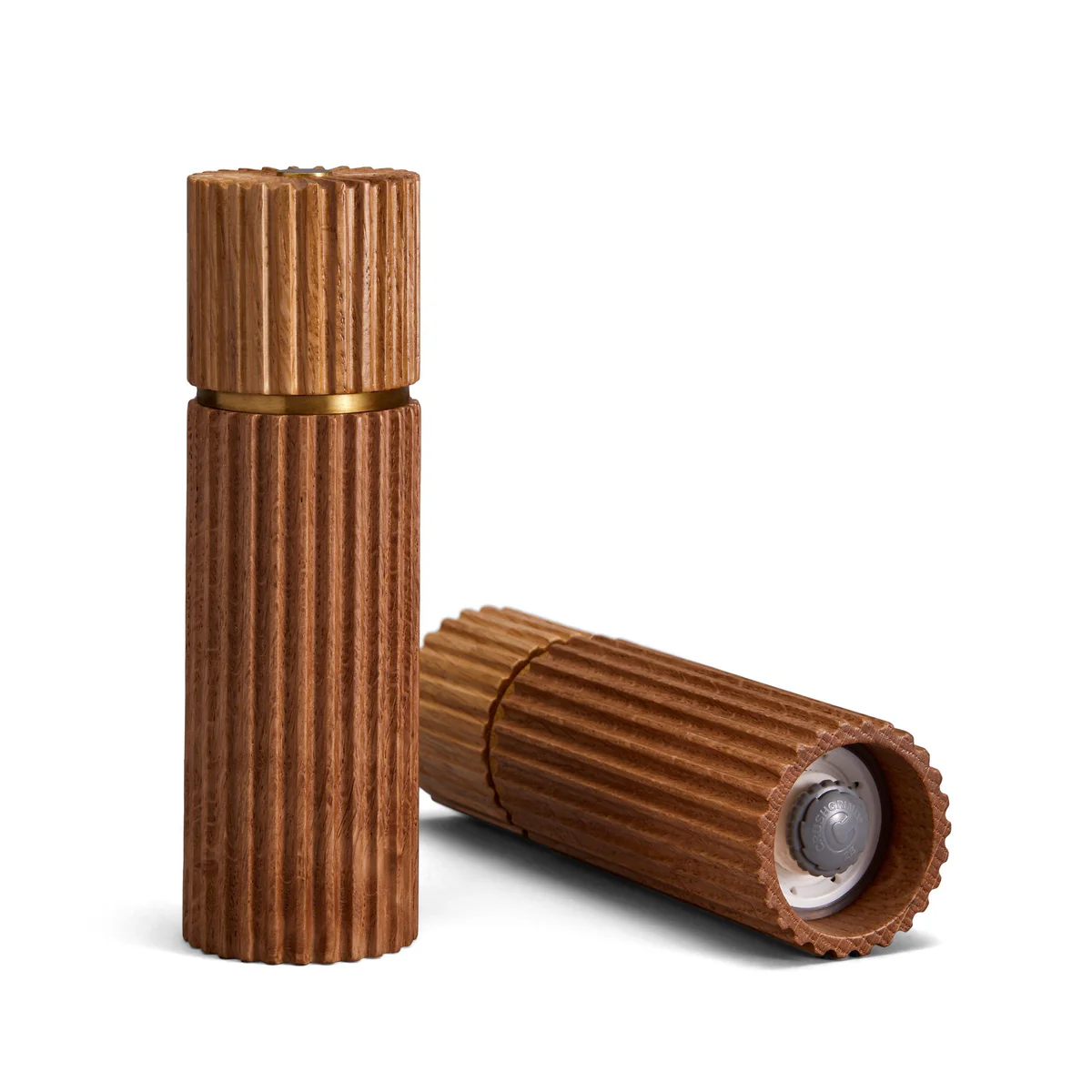 The L'Objet Ionic Salt & Pepper Mill Set Natural Oak features two European oak mills—one upright with a closed lid, the other horizontal and open to reveal a clear inner compartment and metal grinder—for refined seasoning.