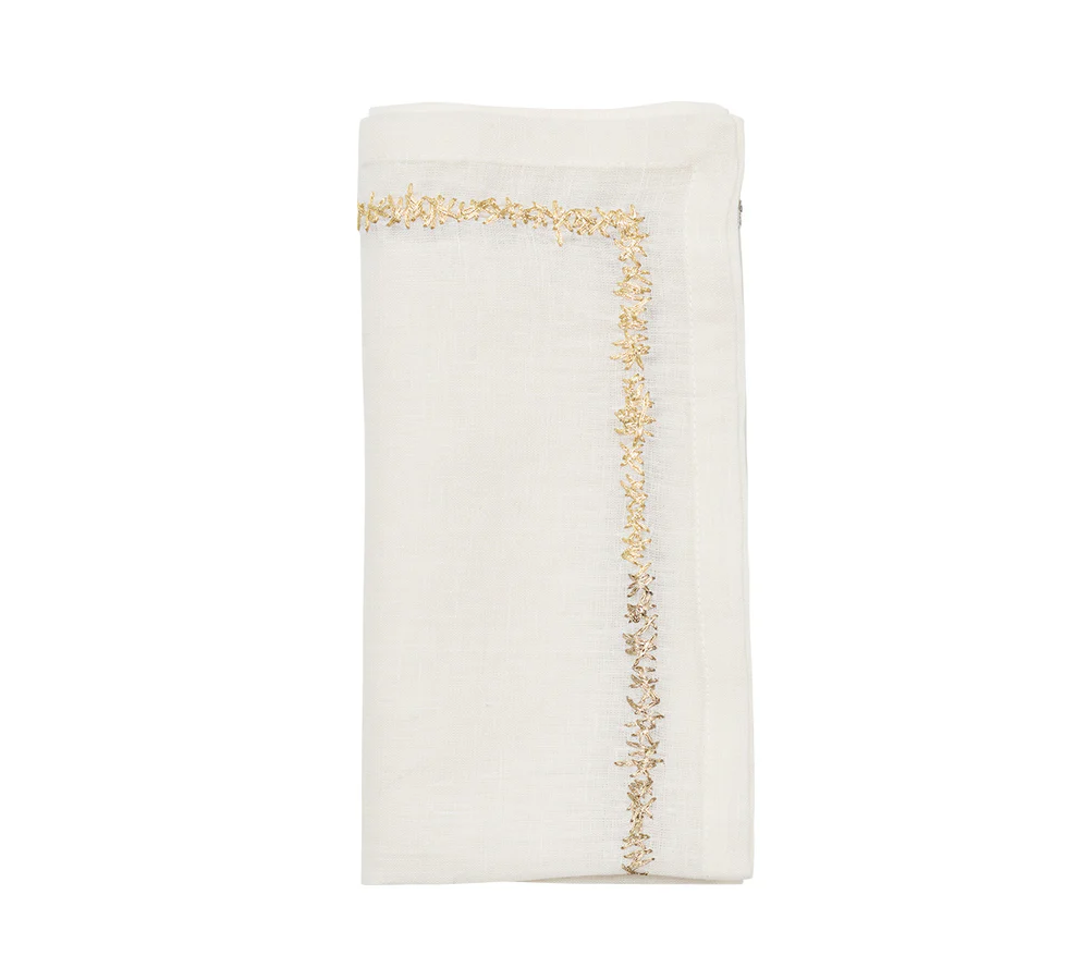 A folded Kim Seybert Aurelia Napkin from the White Gold & Silver set of 4 is shown on a white background, featuring embroidered linen with a gold border—ideal for elevating a luxury table setting.