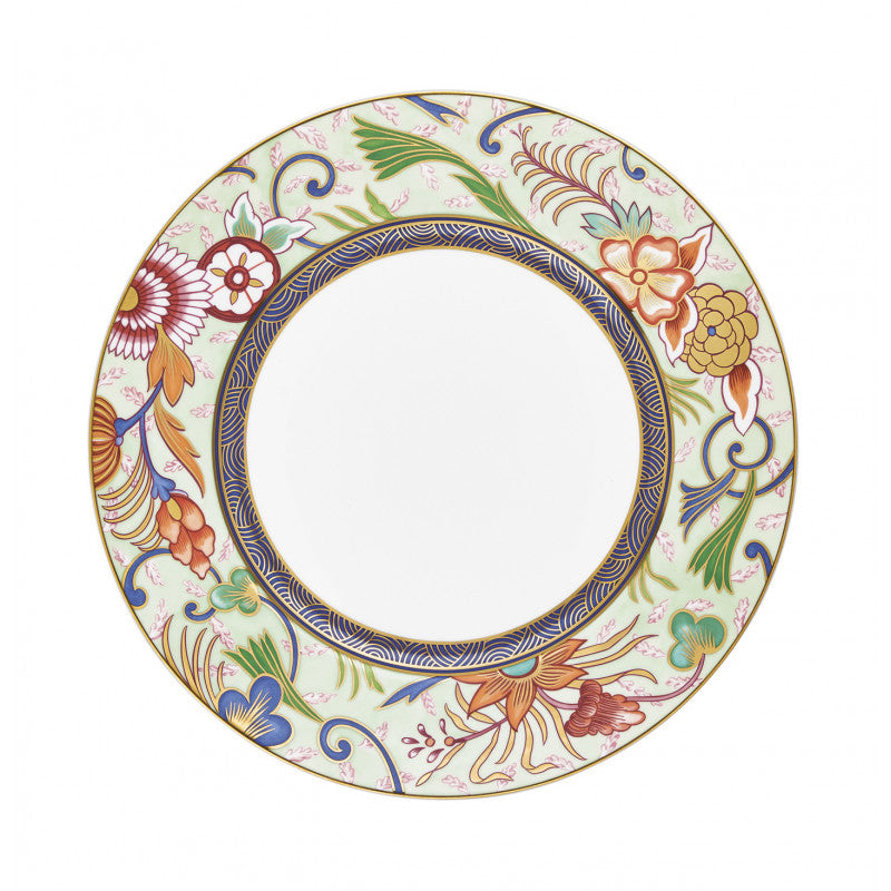 The Raynaud Imari Dinnerware plate features hand-painted porcelain with a white center, a gold-outlined floral and leaf design in red, yellow, blue, and green inspired by Japanese art, and a blue geometric border near the center.