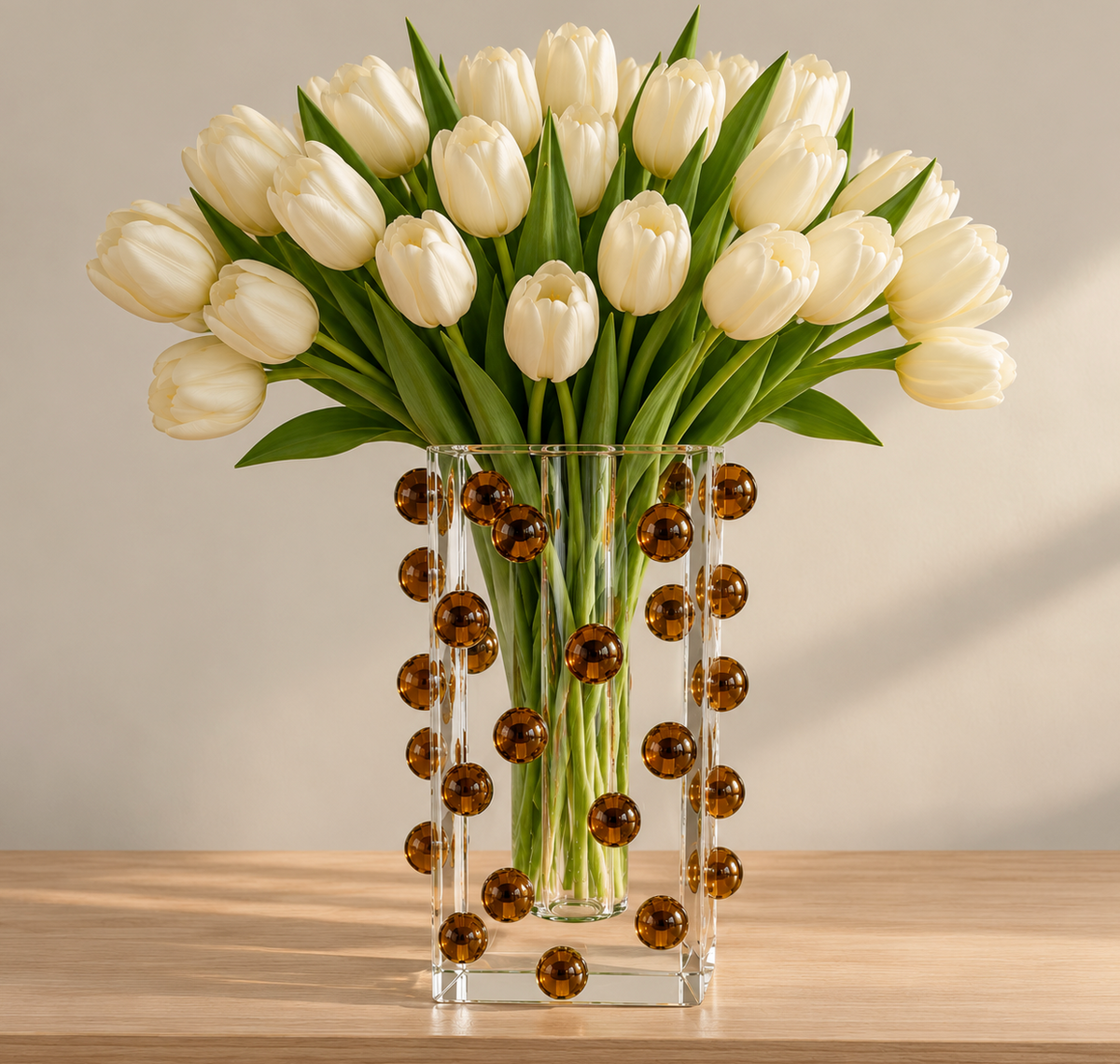 A large bouquet of white tulips in a clear, square Tizo Scattered Balls Vase Brown.