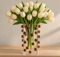 A large bouquet of white tulips in a clear, square Tizo Scattered Balls Vase Brown.