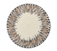 The Diadem Placemat Set of 2 by Kim Seybert features a cream center with a gold, brown, black, and blue sunburst beaded design—an elegant accent to elevate any dining setting.