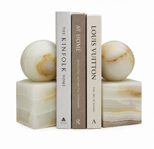 Two light green Apollo Onyx Ball Bookends - Light Green Honed, each consisting of a cube base topped with a sphere, holding three books upright.
