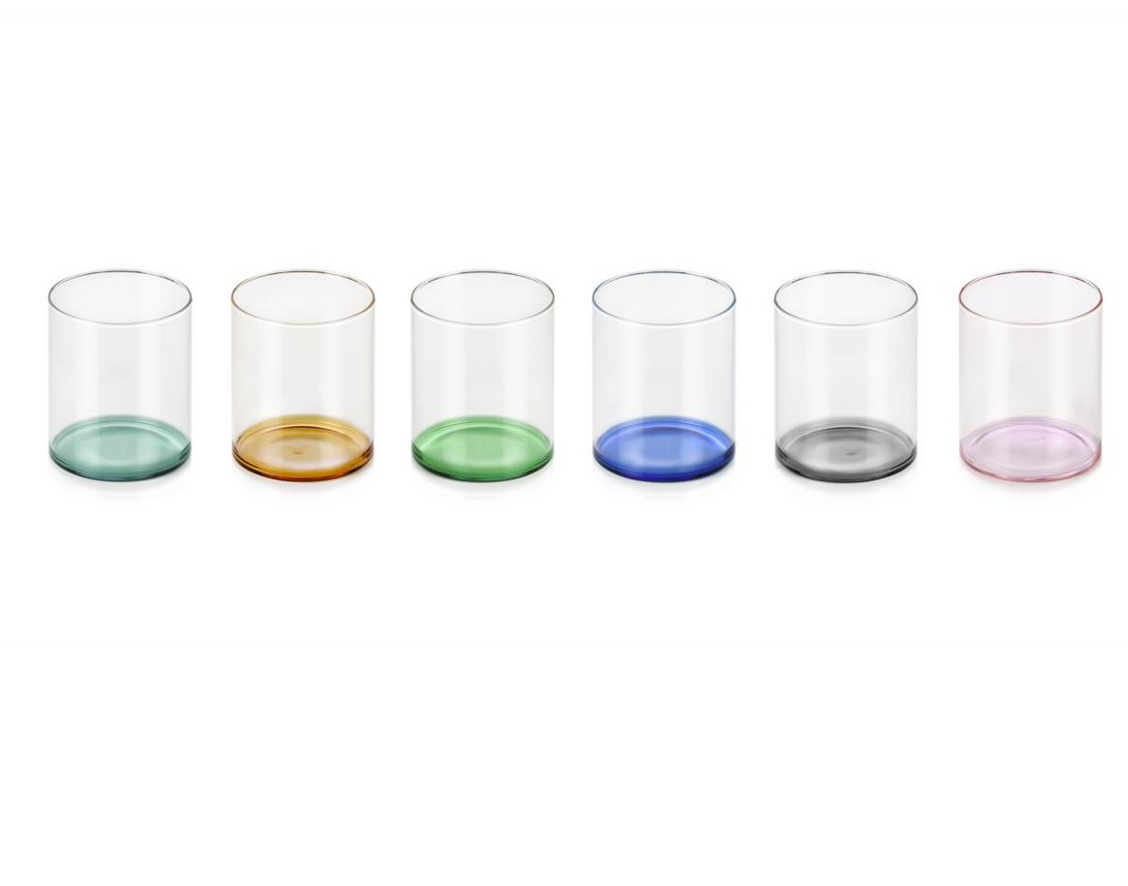 The Fondale Tumbler Set of 6 - Assorted by Ichendorf Milano features hand-blown glass tumblers, each with a differently colored borosilicate glass base—green, amber, light green, blue, gray, and pink—arranged in a row.
